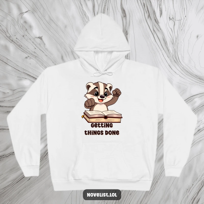 Funny cheerful badger character pounding a fist on a written page, depicted on a warm hoodie, celebrating authorial success.